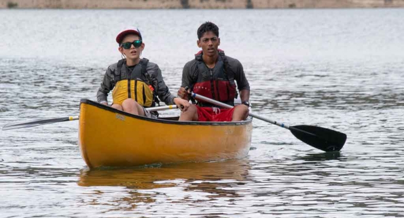 two boys paddle a yellow canoe on an outward bound course in the pacific northwest